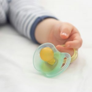 Close up of baby little hand with a pacifier dummy
