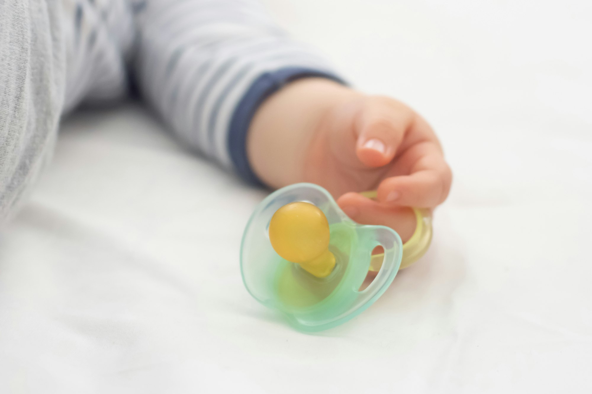 Close up of baby little hand with a pacifier dummy